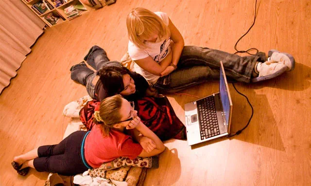 노트북으로 무언가 보고 있는 세 명의 여자