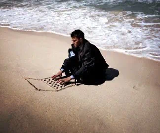 바닷가 모래 사장에 노트북 그려 놓고 컴퓨터 하는 시늉하는 남자